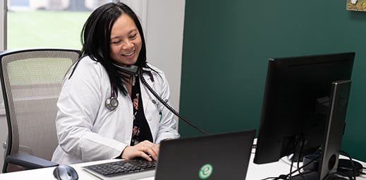 physician on phone while on computer