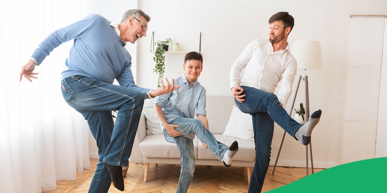 three generations of males laughing while doing the air guitar motion