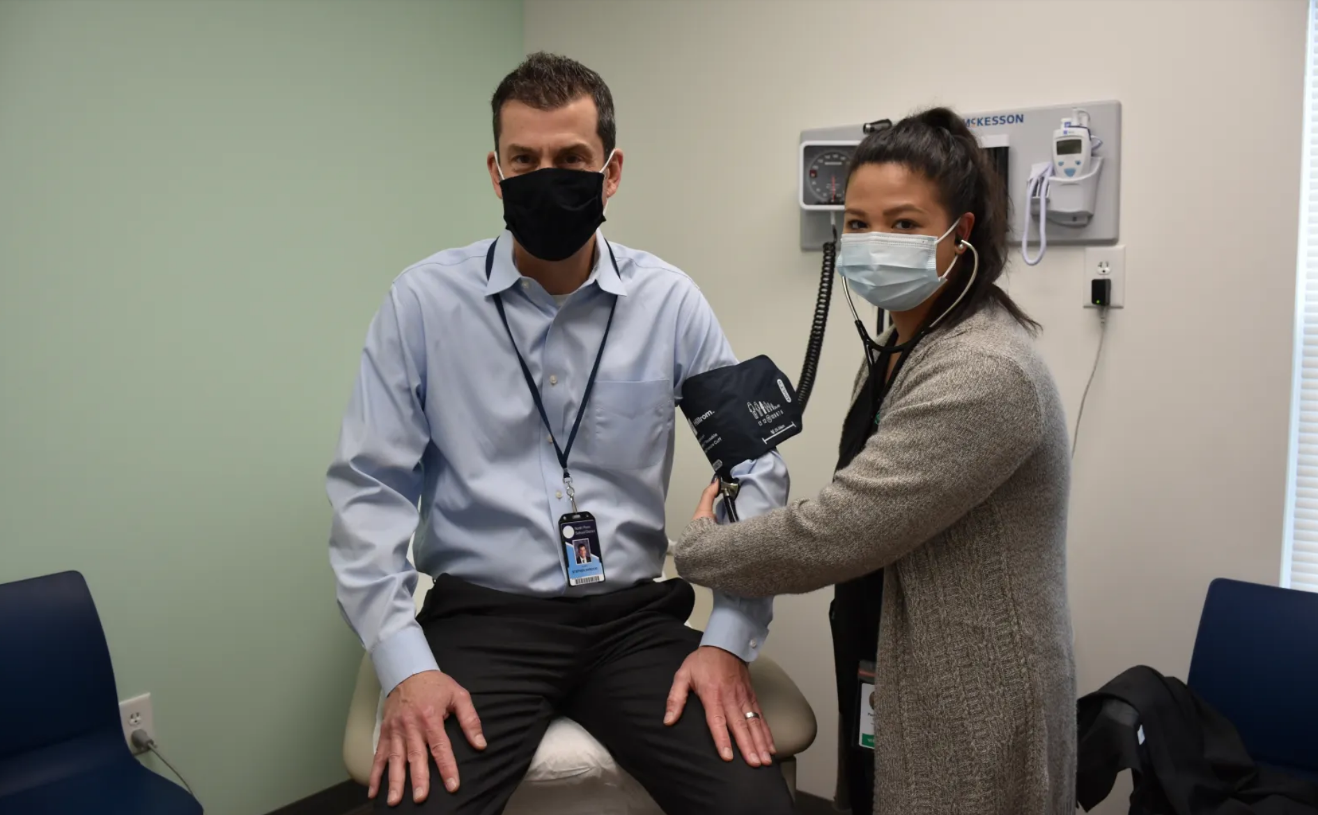 doctor and patient wearing masks during vitals check